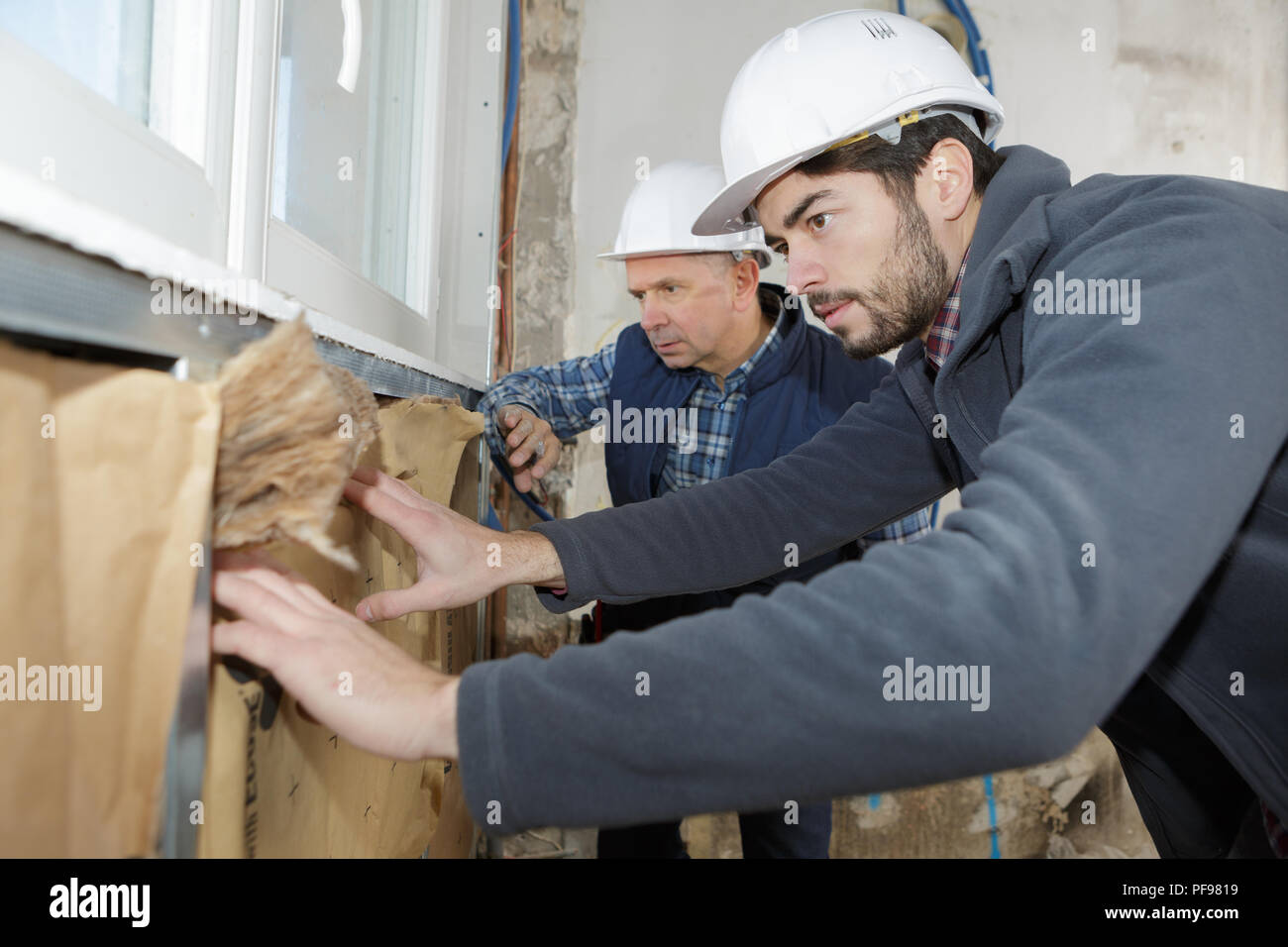 construction worker insulating house walls Stock Photo
