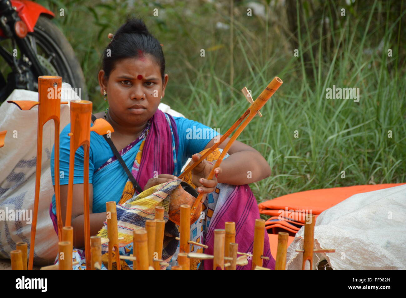 A vendor with her toy Ektara or one string musical instrument at the Sonajhuri haat near Santiniketan, Bolpur in the Birbhum district of West Bengal,  Stock Photo