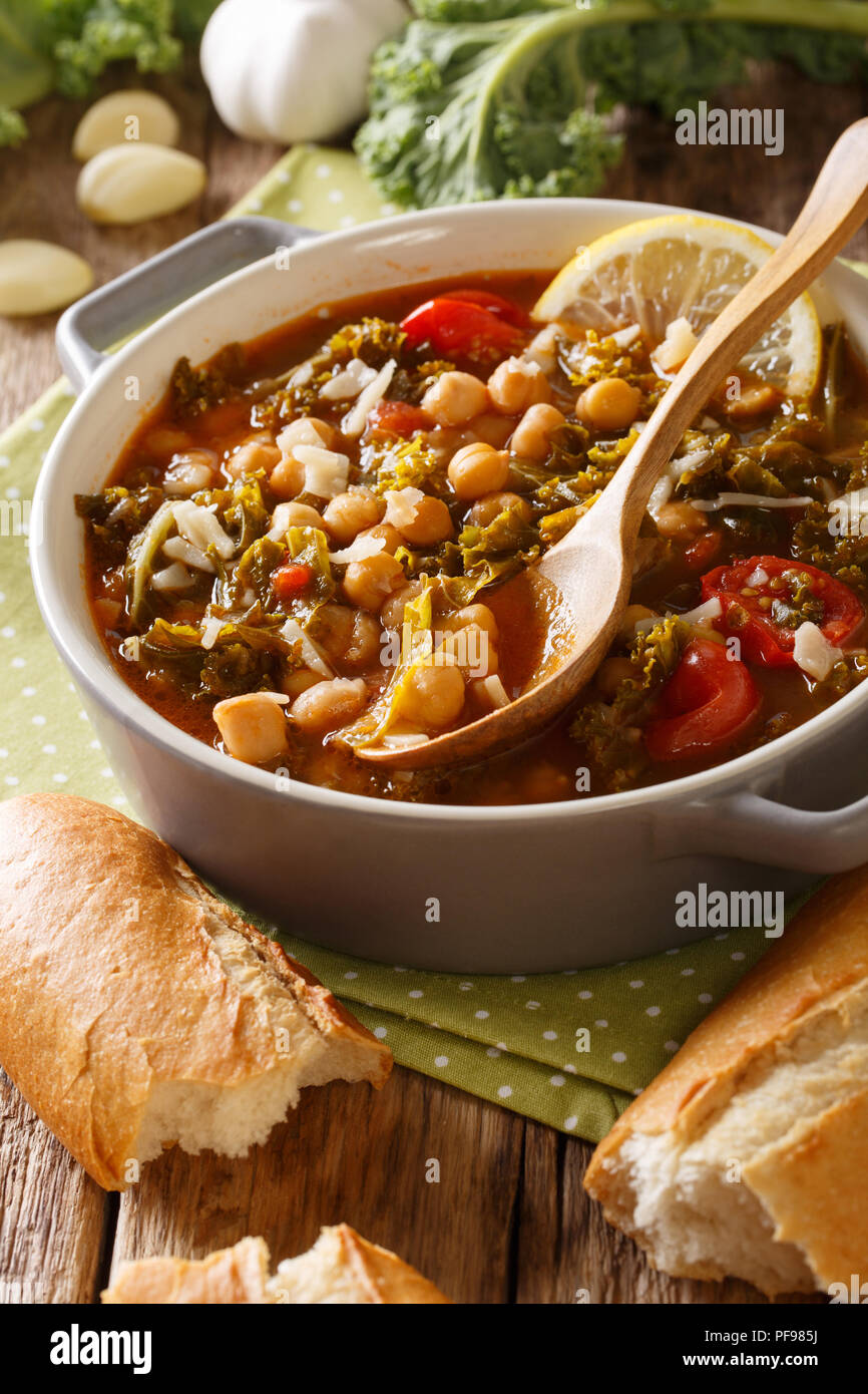 Stewed kale cabbage with chickpeas and vegetables close-up on the table. vertical Stock Photo