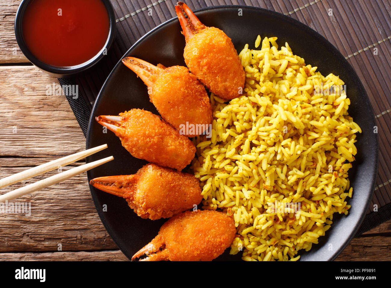 Deep fried crab claws in breadcrumbs of surimi with spicy yellow rice