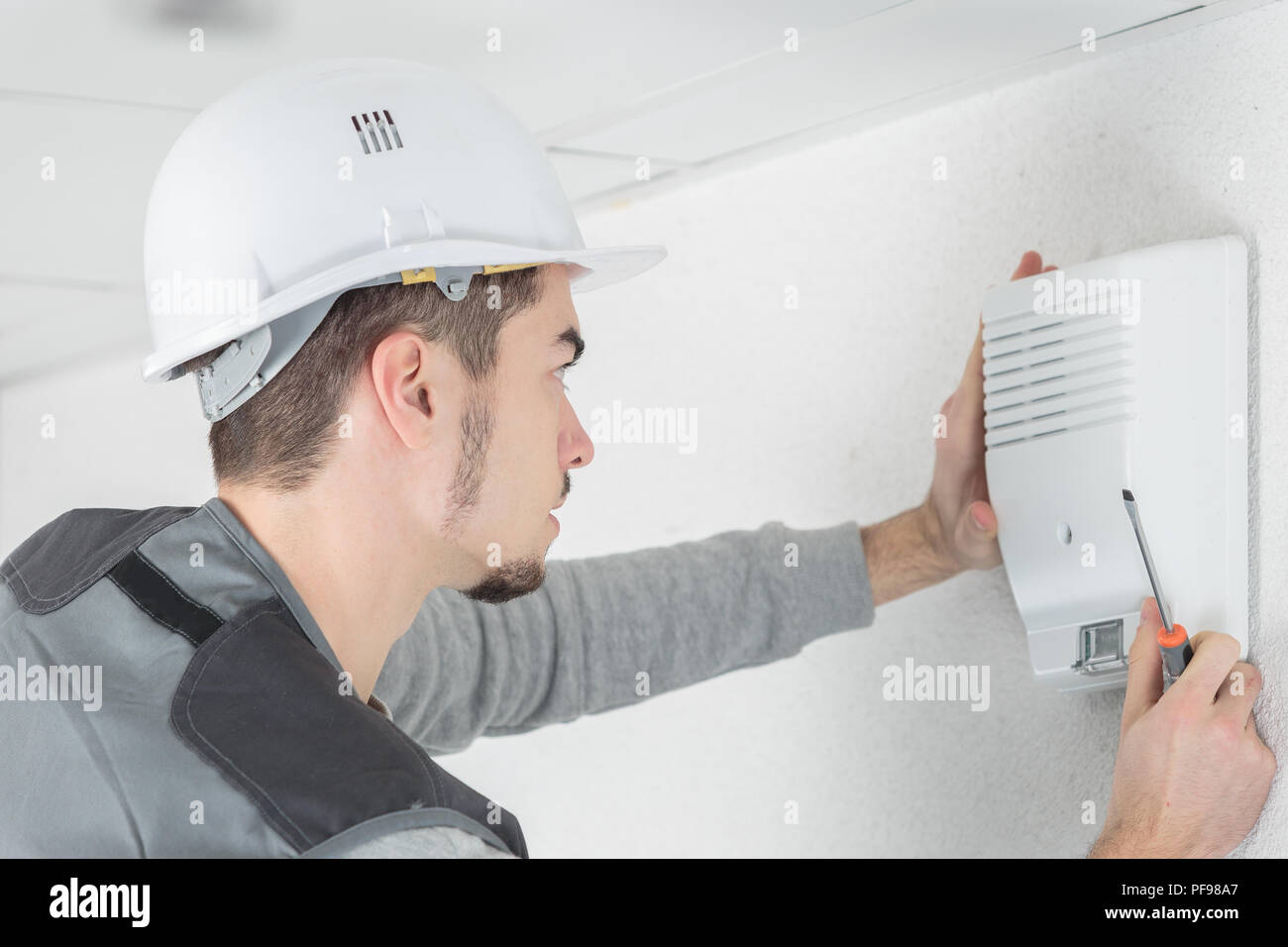 technician checks burglar alarm in professional building Stock Photo