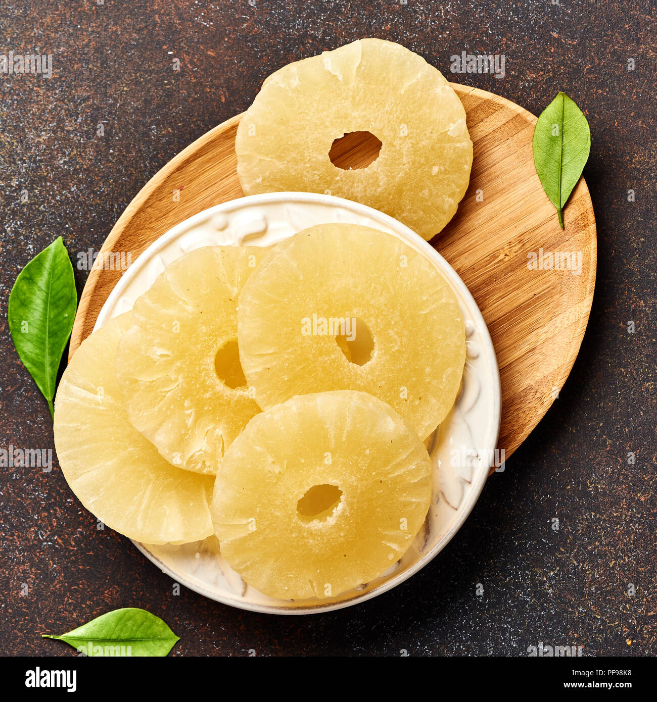 Dried pineapple rings on a brown table. Top viw of sweet paneapple