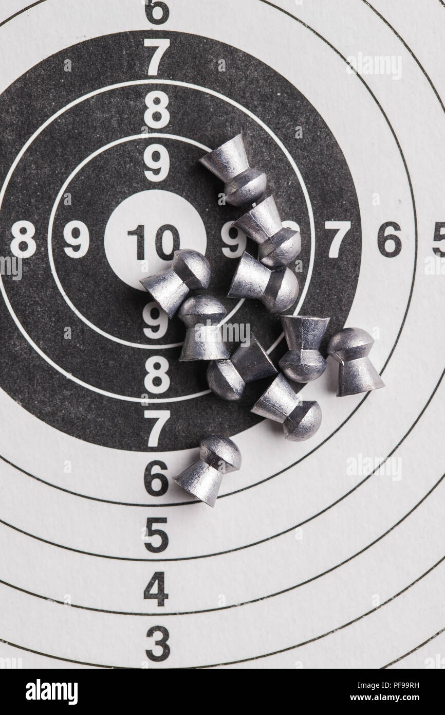 Lead airgun pellets on paper target. Stock Photo