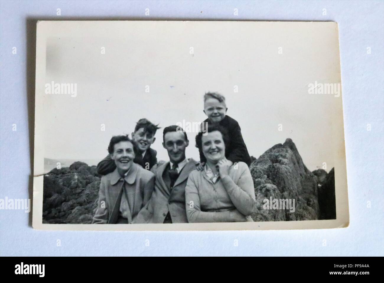 Social History - Black and white old photograph showing family posing on rocks on holiday - 1930s / 1940s Stock Photo