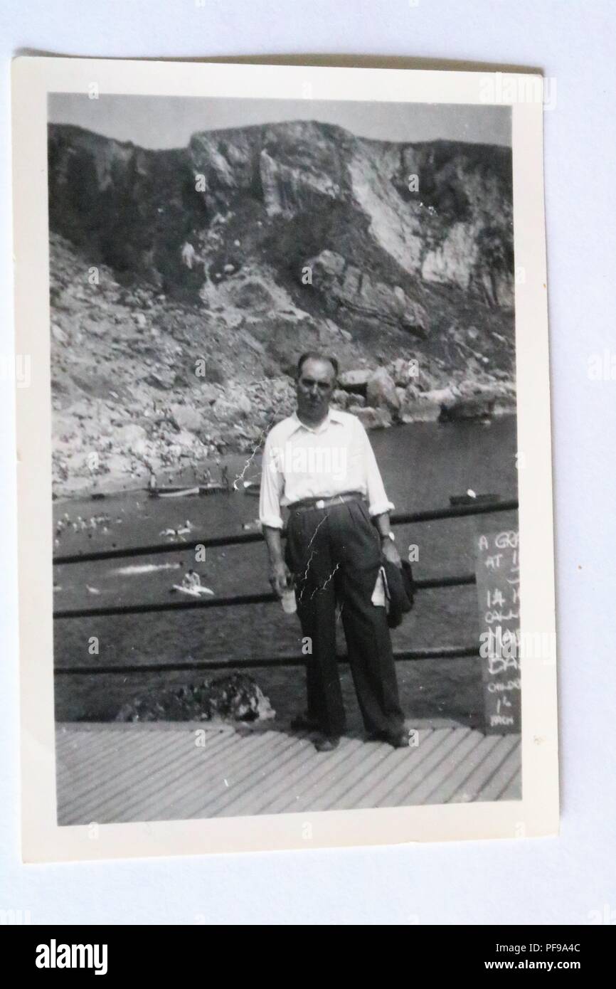 Social History - Black and white old photograph showing a man on his holidays in Ansteys Cove, Torquay, Devon, UK 1950s Stock Photo