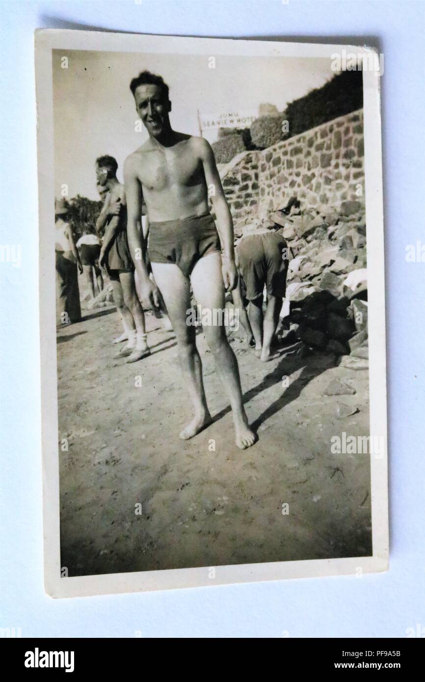 Social History - Black and white old photograph showing man wearing swimming trunks on a beach - 1930s / 1940s Stock Photo