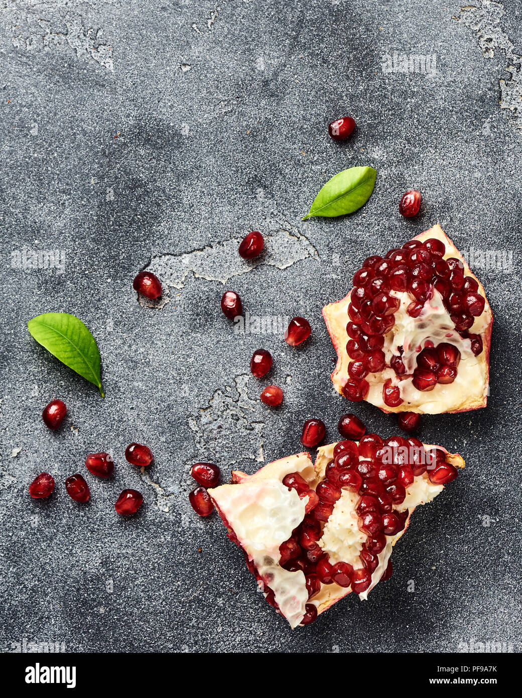Pomegranate fruit with seeds on gray background with copy space. Top view. Stock Photo
