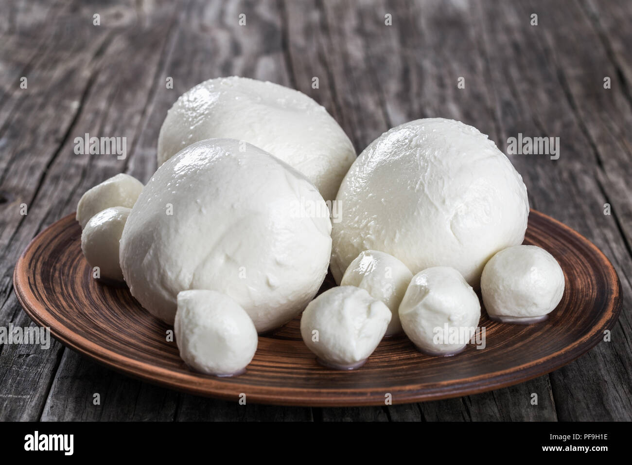 mozzarella balls on a clay dish on an old rustic table,  close-up Stock Photo