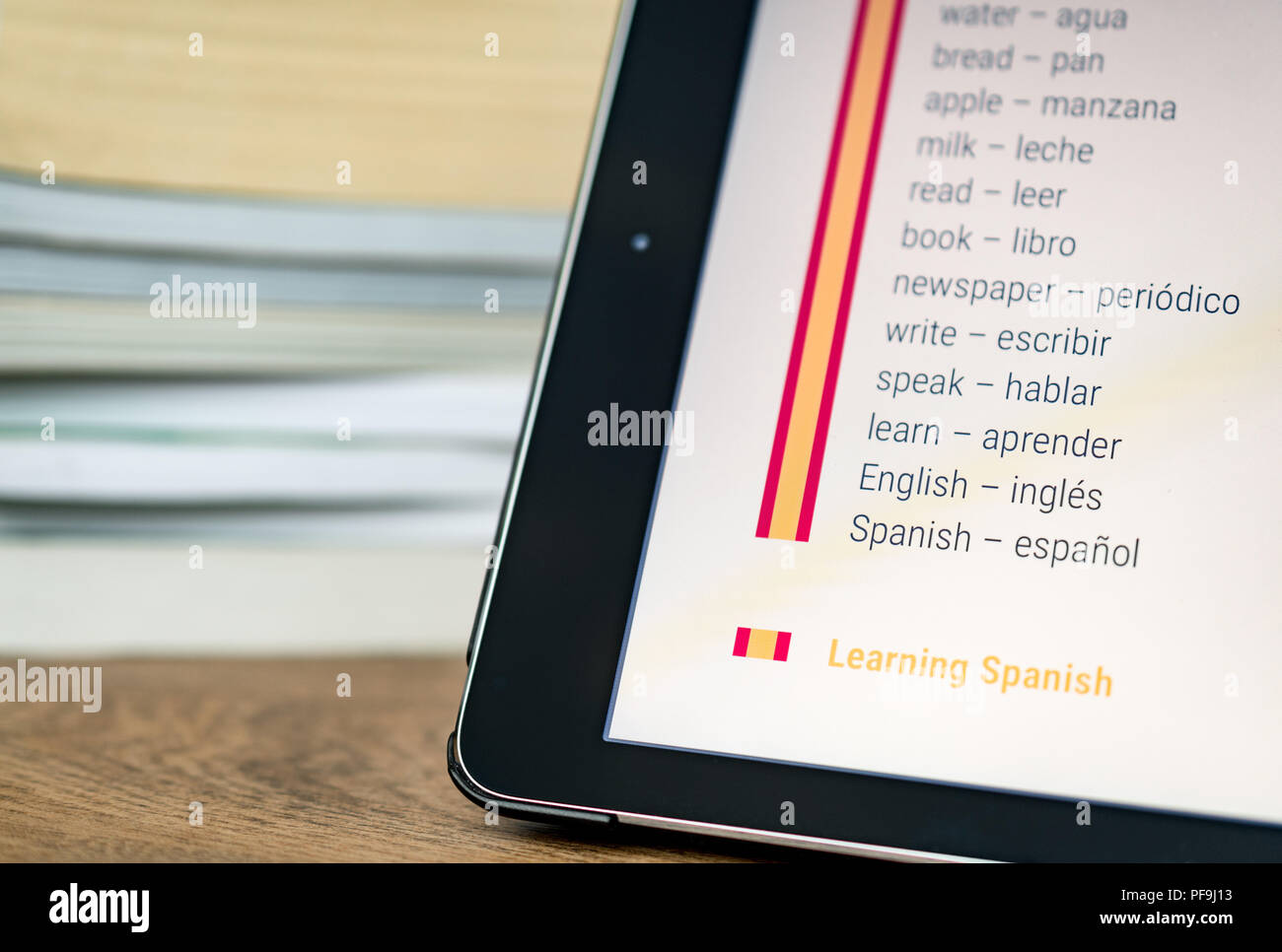 Learning Spanish using a tablet with books in the background Stock Photo Alamy