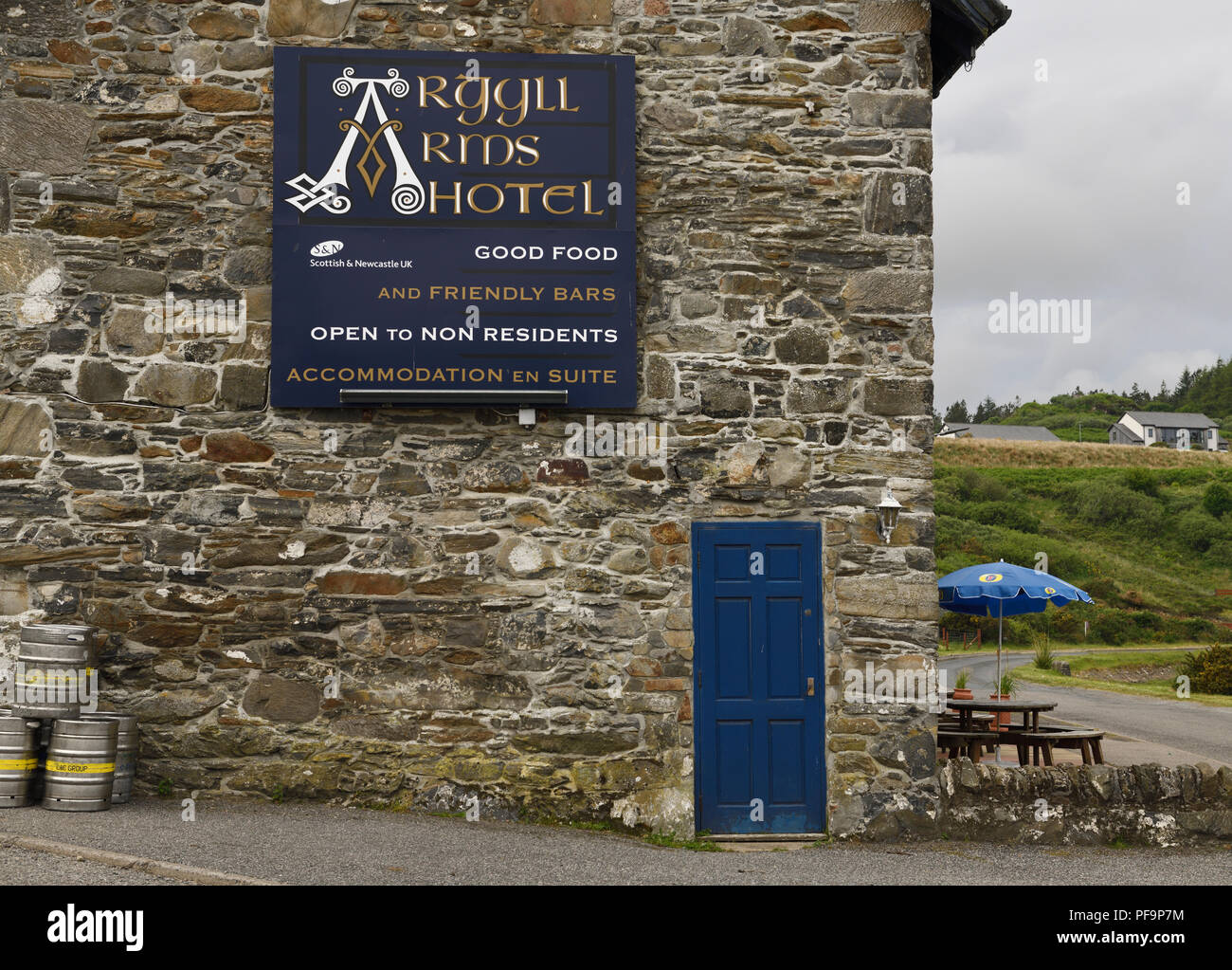 Stone wall of Argyll Arms Hotel with blue sign open to non residents and beer kegs in Bunessan on Isle of Mull Scotland UK Stock Photo