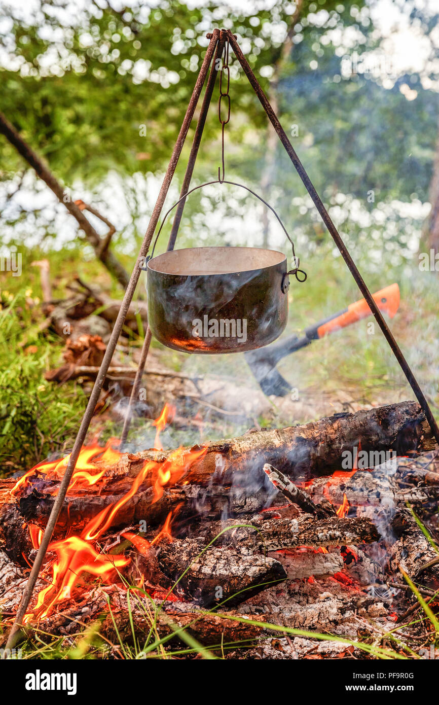 camping cooking on campfire with old iron pots Stock Photo - Alamy