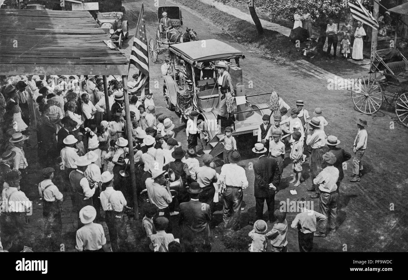 Black and white photograph showing a group of suffragists, riding a float fashioned from a Liberty Bell cast on a truck bonnet, surrounded by a crowd of onlookers, during a campaign stop in Sligo, Pennsylvania, 1915, 1915. () Stock Photo