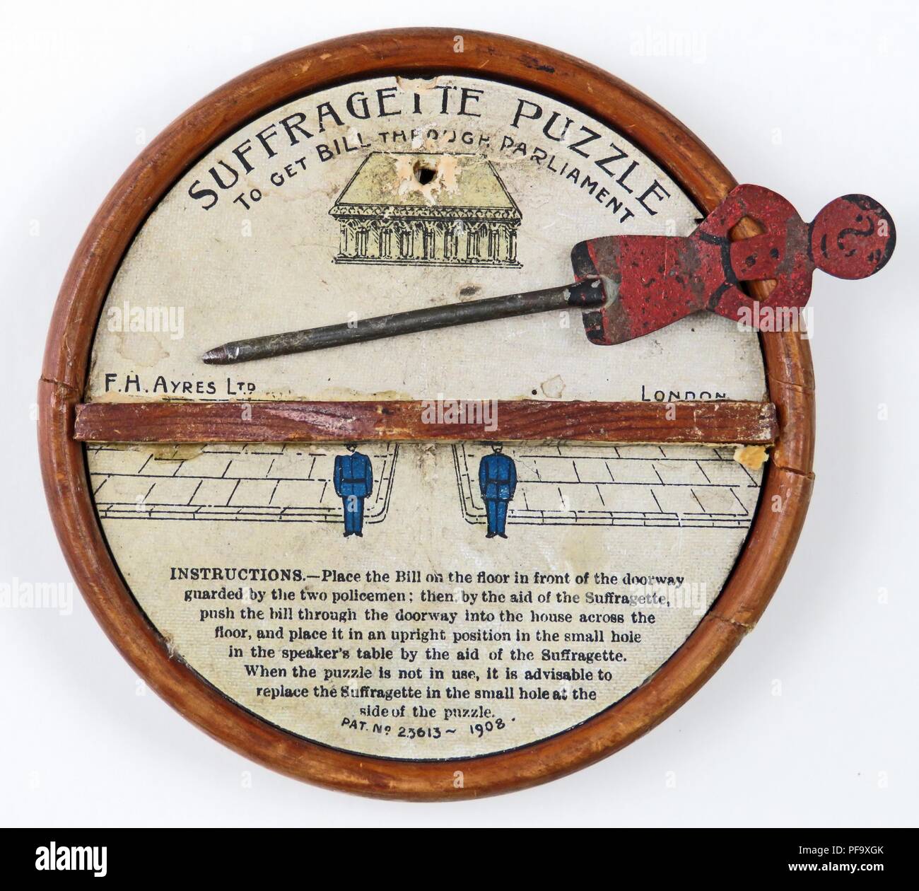 Suffragette Puzzle To Get Bill Through Parliament game, with a metal pin, pushed by a red suffragette figure, which would stall at the wooden barrier because of magnets placed underneath, intended to illustrate the difficulty of passing a suffrage bill through the English parliament,  made by FH Ayers Ltd of Aldersgate Street in London, and produced for the British Market, 1907. Photography by Emilia van Beugen. () Stock Photo