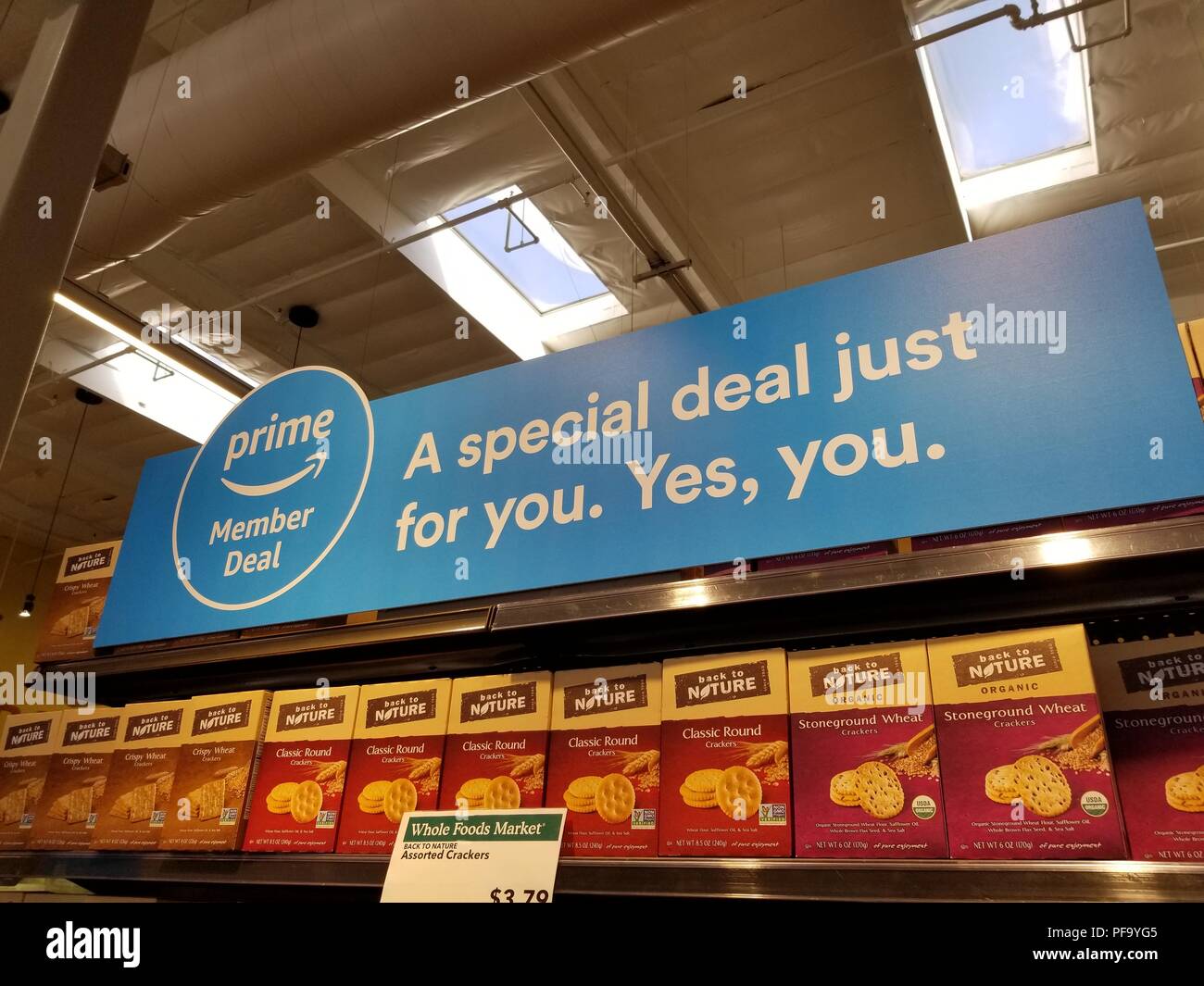 At a Whole Foods Market grocery store in San Ramon, California, signage advertises new discounts for members of the Amazon Prime service from Amazon, which acquired Whole Foods Market in 2017, June, 2018. () Stock Photo