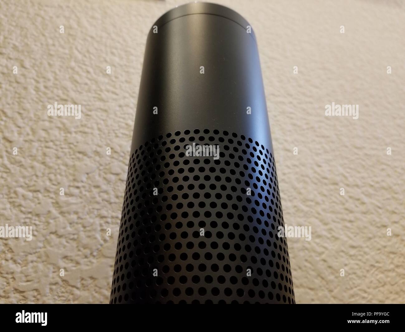 Low-angle, close-up view of Amazon Echo smart speaker using the Alexa service against a white wall in a home setting, suggesting an ominous or imposing presence, San Ramon, California, May 31, 2018. () Stock Photo