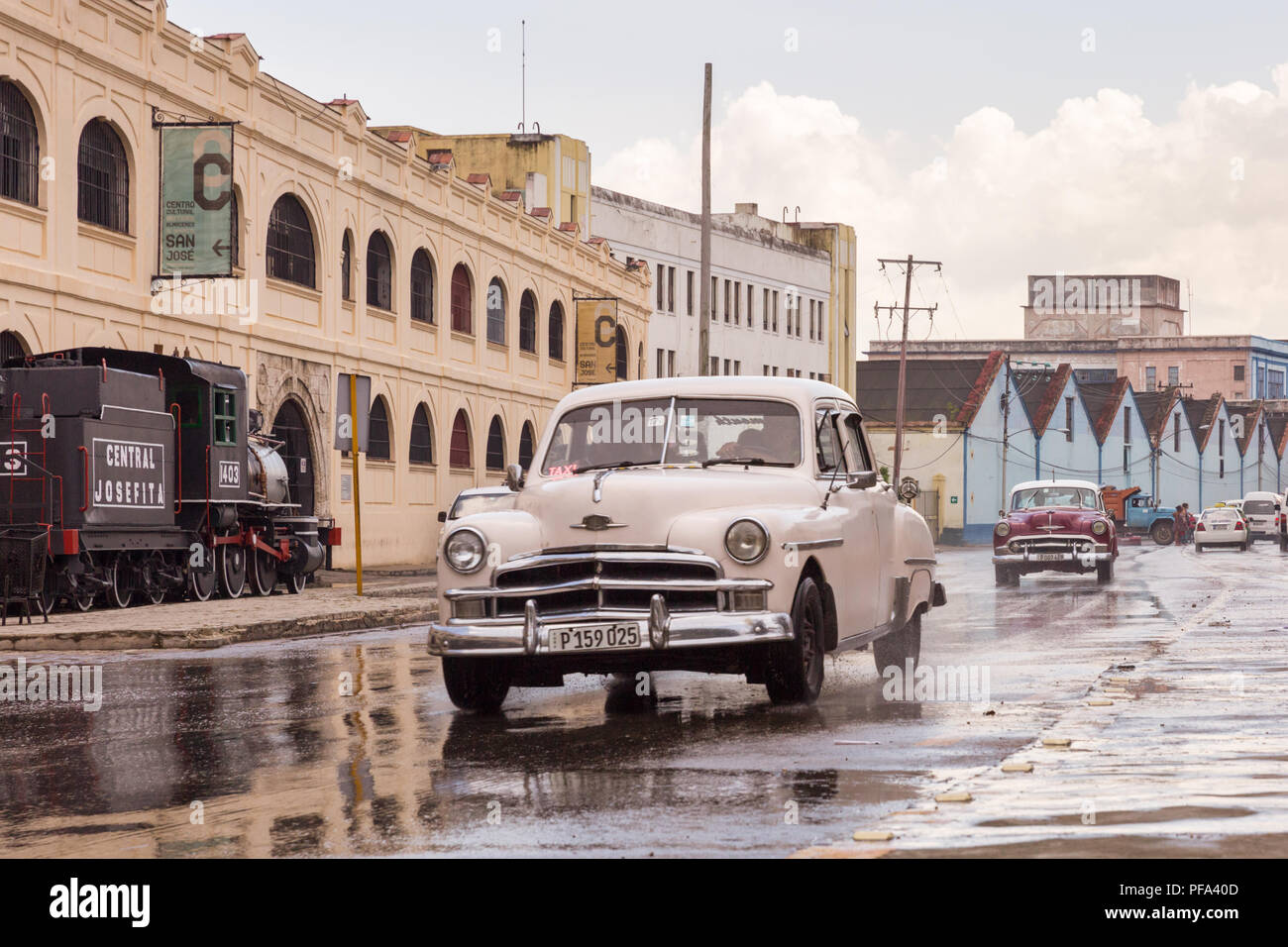 Street scene after the rain, American classic car driving in Habana Vieja, Cuba Stock Photo