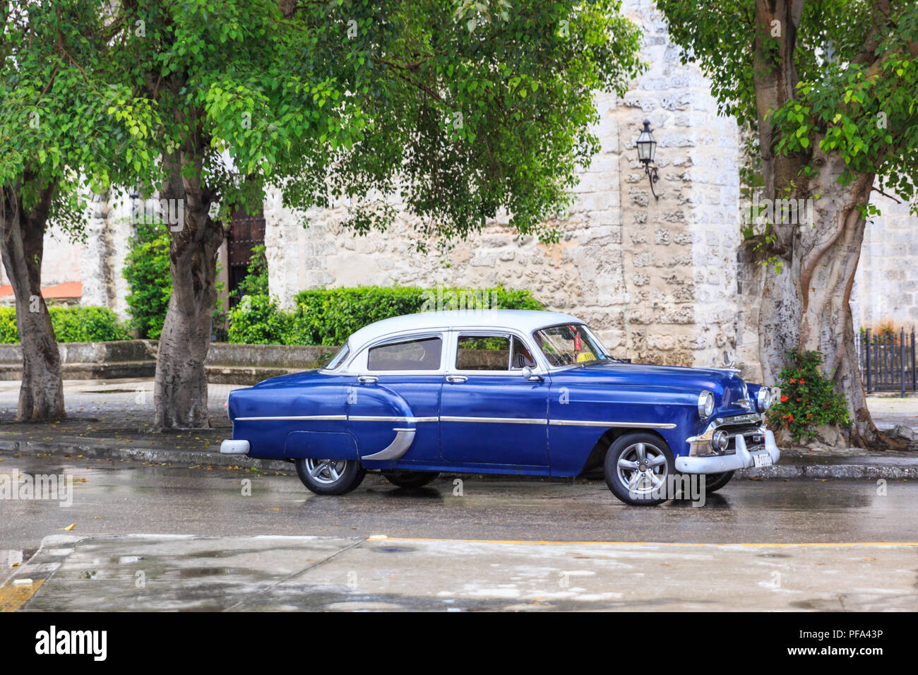 Old American classic car driving along road, blue vintage look, Havana, Cuba Stock Photo