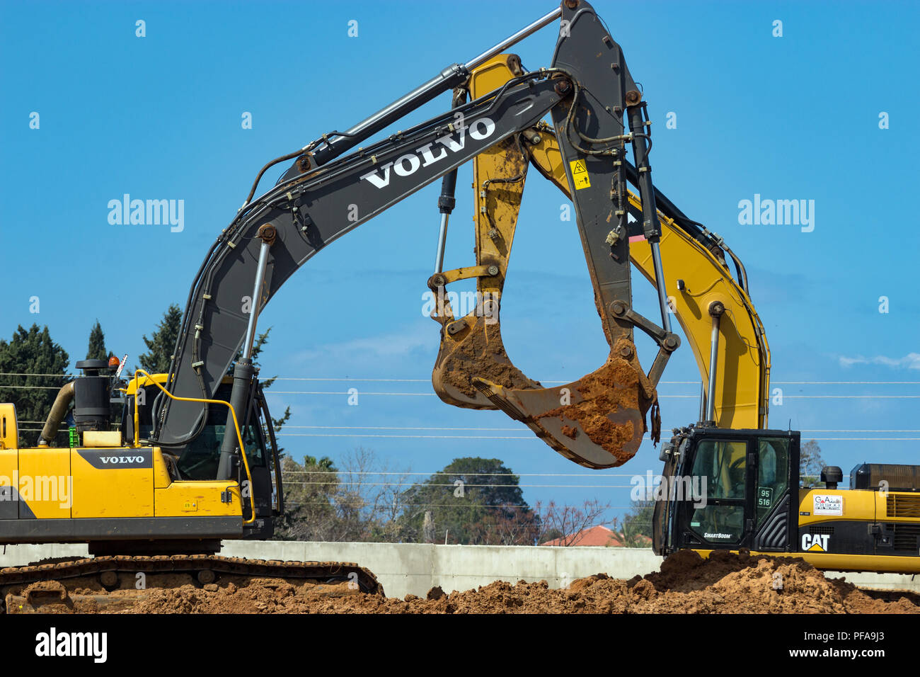 Two yellow excavators in construction site Stock Photo - Alamy