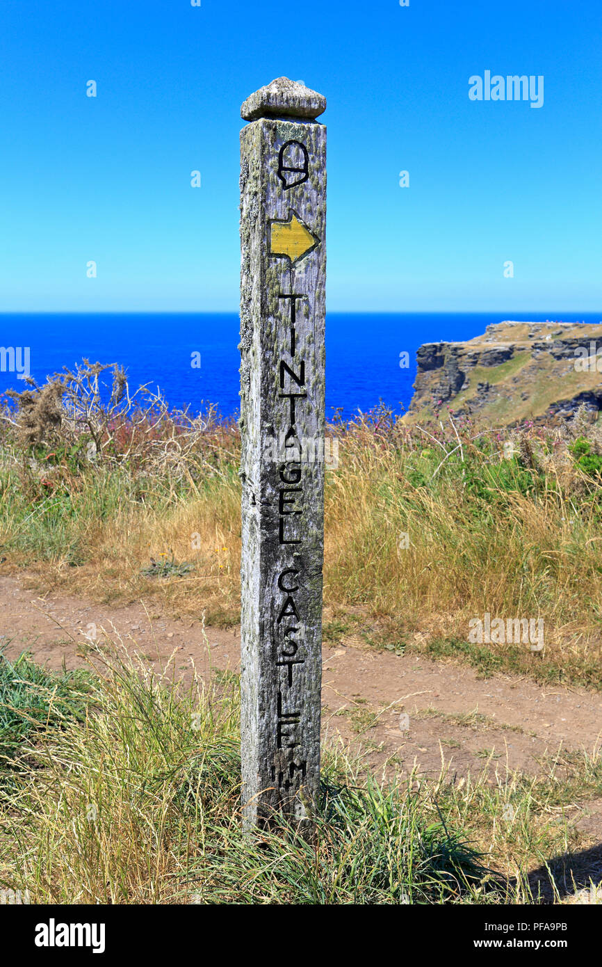 Wooden long distance footpath marker post on the South West Coast Path on Glebe Cliff pointing to Tintagel Castle, Tintagel, Cornwall, England, UK. Stock Photo