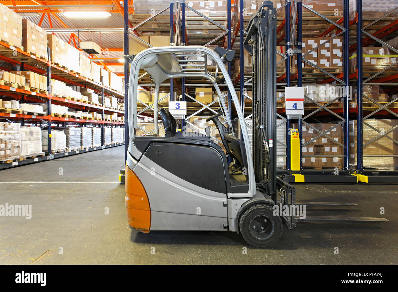 Electric forklift in distribution warehouse Stock Photo - Alamy