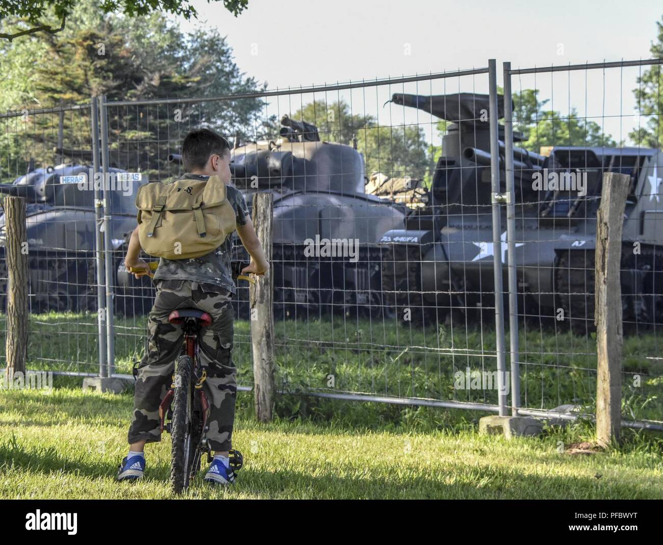 A young French boy dressed in camouflage pauses on his bike ride to ...