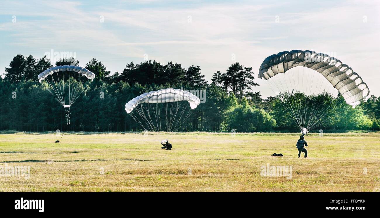 Three paratroopers with the Polish 6th Airborne Brigade land moments apart and begin guiding their parachutes to the ground for repacking on June 6, 2018. The Polish Airborne utilize Ram-air-style parachutes, which allows for greater control during their descent. This helps ensure a successful, injury-free landing. (Michigan Army National Guard Stock Photo
