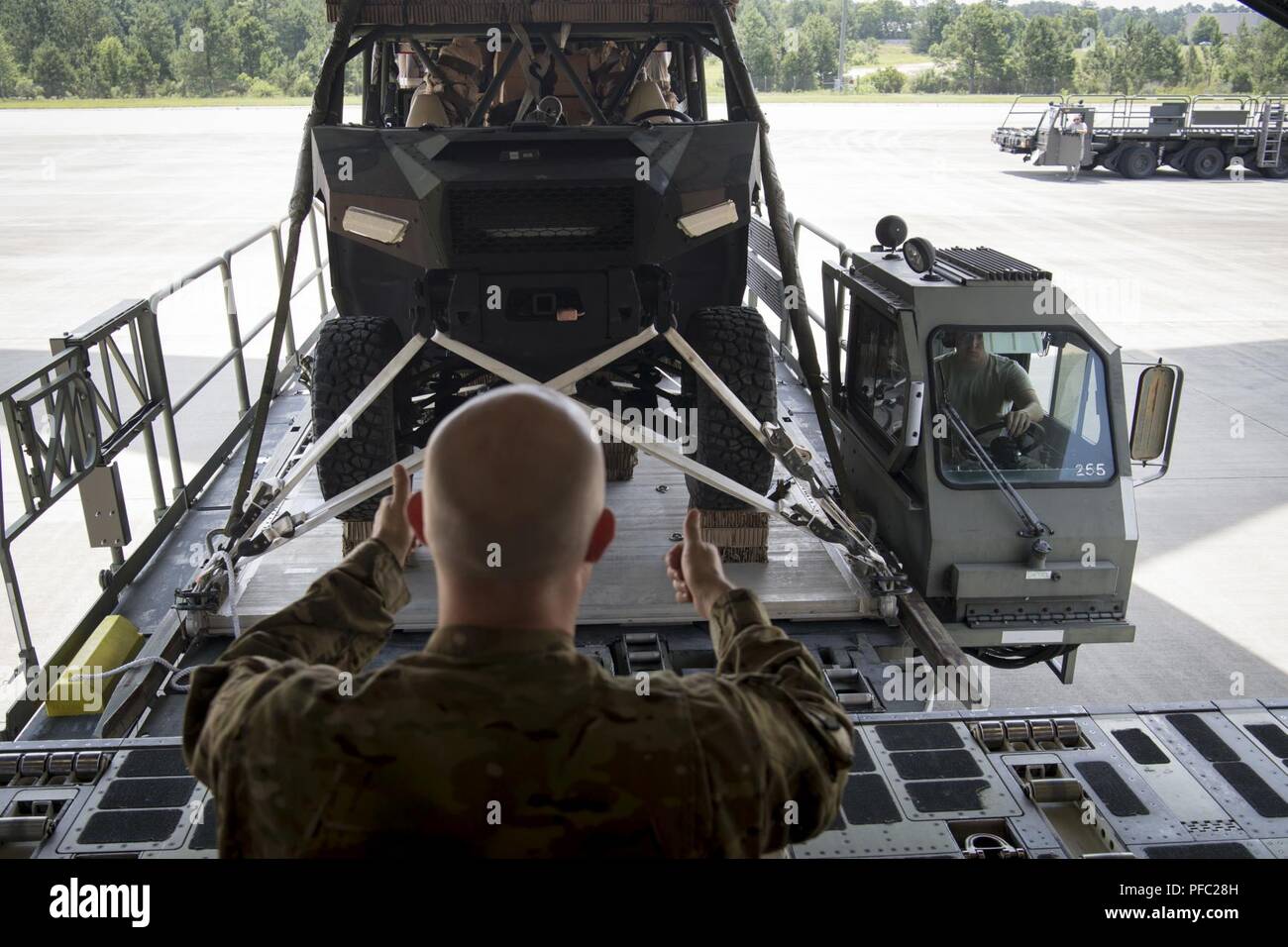 U.S. Air Force Tech Sgt. Eric Morris, loadmaster, 16th Airlift Squadron, Joint Base Charleston, S.C., loads Dagor Ultra-light Combat Vehicles onto C-17 Globemaster III's at Pope Army Air Field, N.C., during Exercise Swift Response 18 (SR18) June 7, 2018. SR18 is one of the premier military crisis response training events for multinational airborne forces in the world that demonstrates the ability of America's Global Response Force to work hand-in-hand with joint and total force partners. Stock Photo