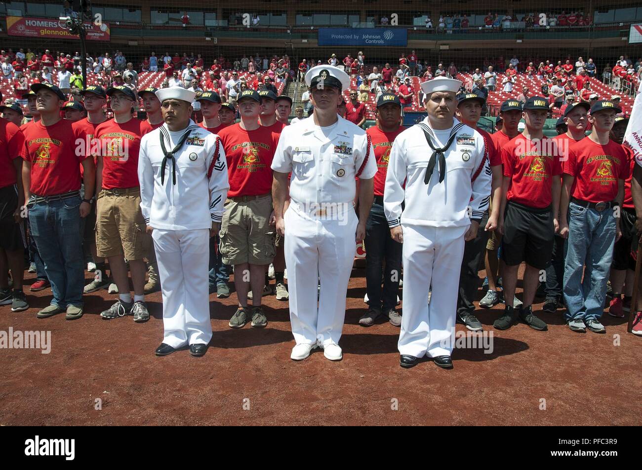 ST. LOUIS (June 7, 2018) – Recruit Division Commanders and recruits assigned to the 60th Cardinal Division stand at attention during a pre-game event at Busch Stadium. The 80 recruits were sworn into the Navy prior to a baseball game between the St. Louis Cardinals and Miami Marlins. The division is named after the Cardinals who have sponsored such groups annually since 1958. Stock Photo