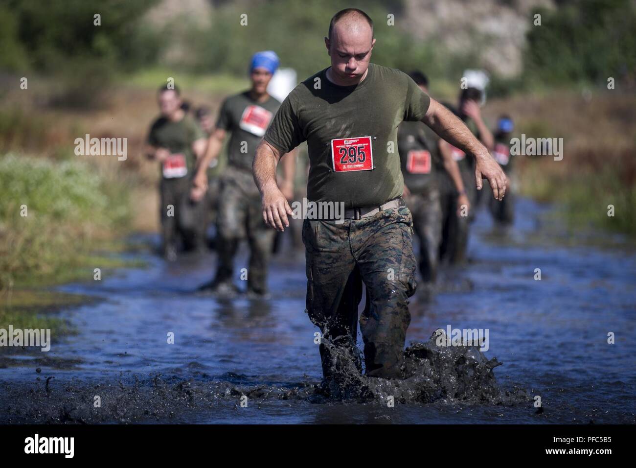 Marines trudge through the, “Chosin Reservoir” portion of the 2018 Mud Run Commanding General’s Cup Team Competition, on Marine Corps Base Camp Pendleton, Calif., June 8, 2018. The race stretched over 10-kilometers around Lake O’Neill on MCB Camp Pendleton. Over 2,000 Marines from numerous units around California and neighboring states participated in the challenge. Stock Photo