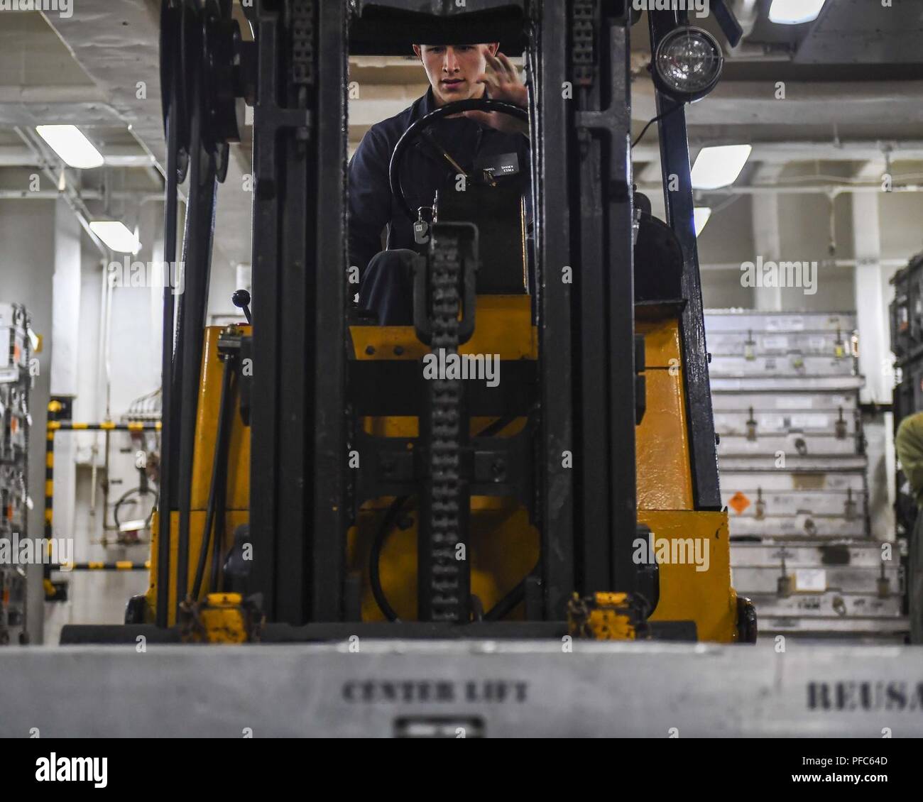 PACIFIC OCEAN (June 7, 2018) – Aviation Ordnanceman 3rd Class Gabriel Snider, a native of Sacramento, Calif., uses a forklift to transfer Rim-7 missiles in the weapons magazine aboard Wasp-class amphibious assault ship USS Essex (LHD 2) during a composite training unit exercise (COMPTUEX). COMPTUEX is the final pre-deployment exercise which certifies the combined Essex Amphibious Ready Group and 13th Marine Expeditionary Unit's abilities to conduct military operations at sea and project power ashore during their upcoming deployment in summer of 2018. Stock Photo