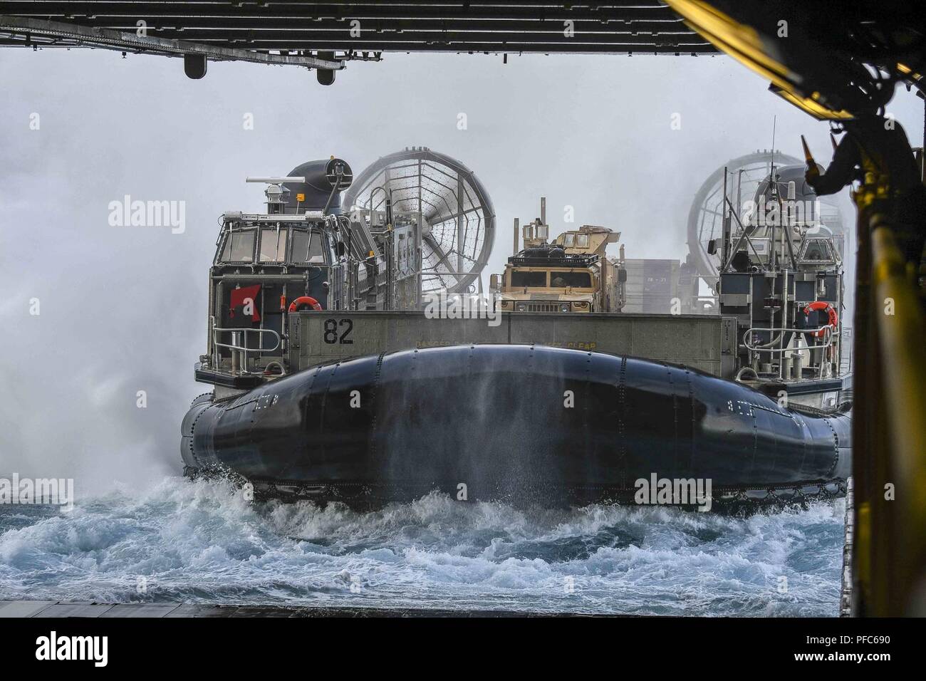OCEAN (June 6, 2018) A landing craft, air-cushion (LCAC) assigned to Assault Craft Unit (ACU) 5 enters the well deck of the Wasp-class amphibious assault ship USS Essex (LHD 2) during a composite training unit exercise (COMPTUEX). COMPTUEX is the final pre-deployment exercise that certifies the combined Essex Amphibious Ready Group (ARG) and 13th Marine Expeditionary Unit’s (MEU) abilities to conduct military operations at sea and project power ashore during their upcoming deployment in summer of 2018. Stock Photo