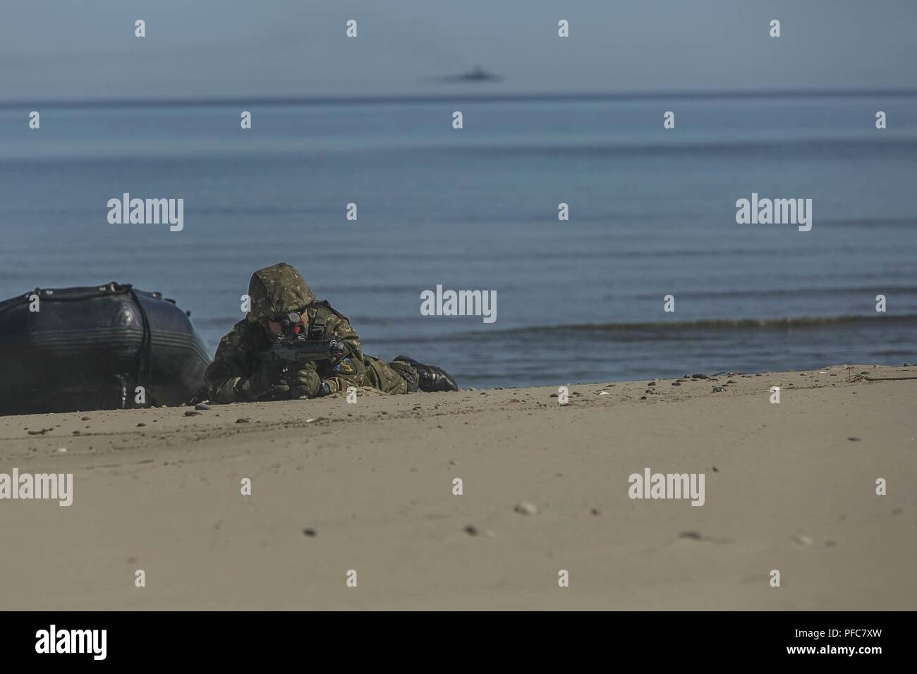 USTKA, Poland (June 8, 2018) A Romanian Marine assigned to the 307th Naval Infantry Battalion, provides security as part of a joint personnel recovery (JPR) training scenario during exercise Baltic Operations (BALTOPS) 2018 Ustka, Poland, June 8. BALTOPS is the premier annual maritime-focused exercise in the Baltic region and one of the largest exercises in Northern Europe enhancing flexibility and interoperability among allied and partner nations. Stock Photo