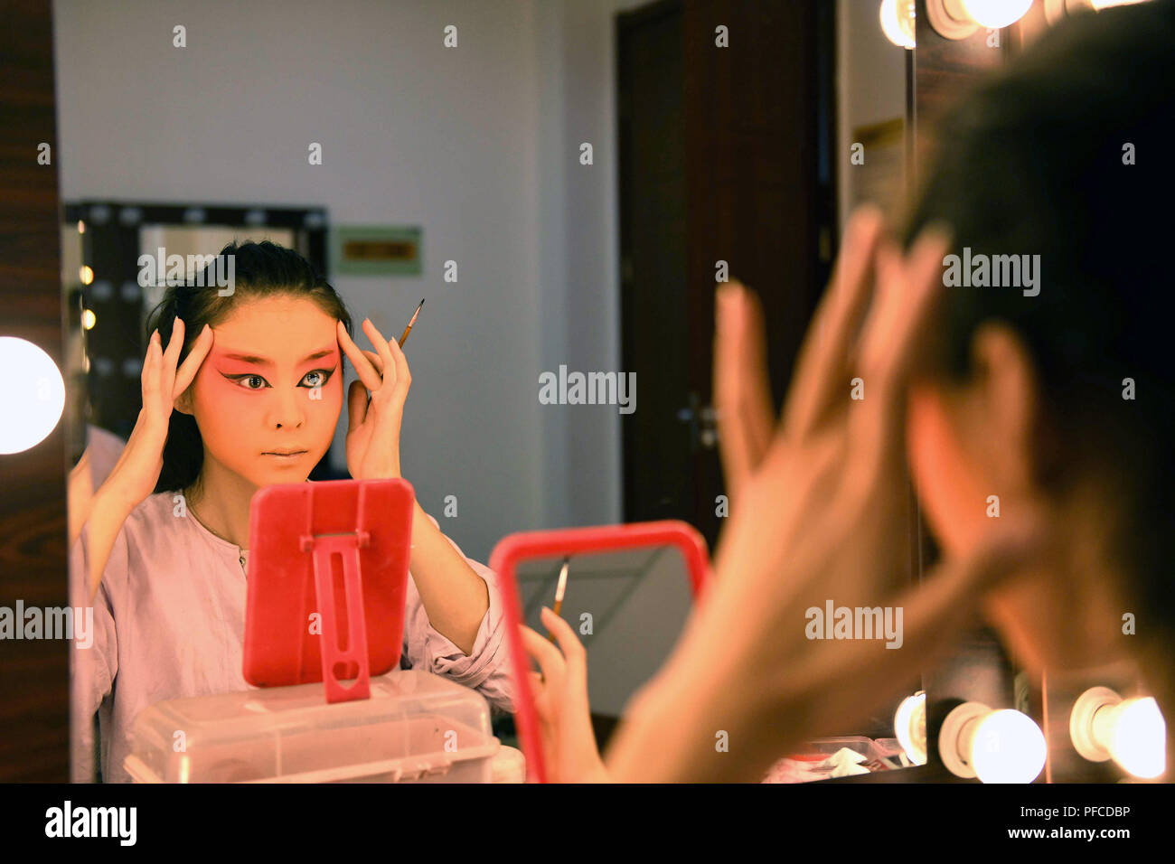 Shijiazhuang, China's Hebei Province. 20th Aug, 2018. A Peking Opera performer puts on makes up before performance at a theater in Shijiazhuang, north China's Hebei Province, Aug. 20, 2018. Credit: Chen Qibao/Xinhua/Alamy Live News Stock Photo
