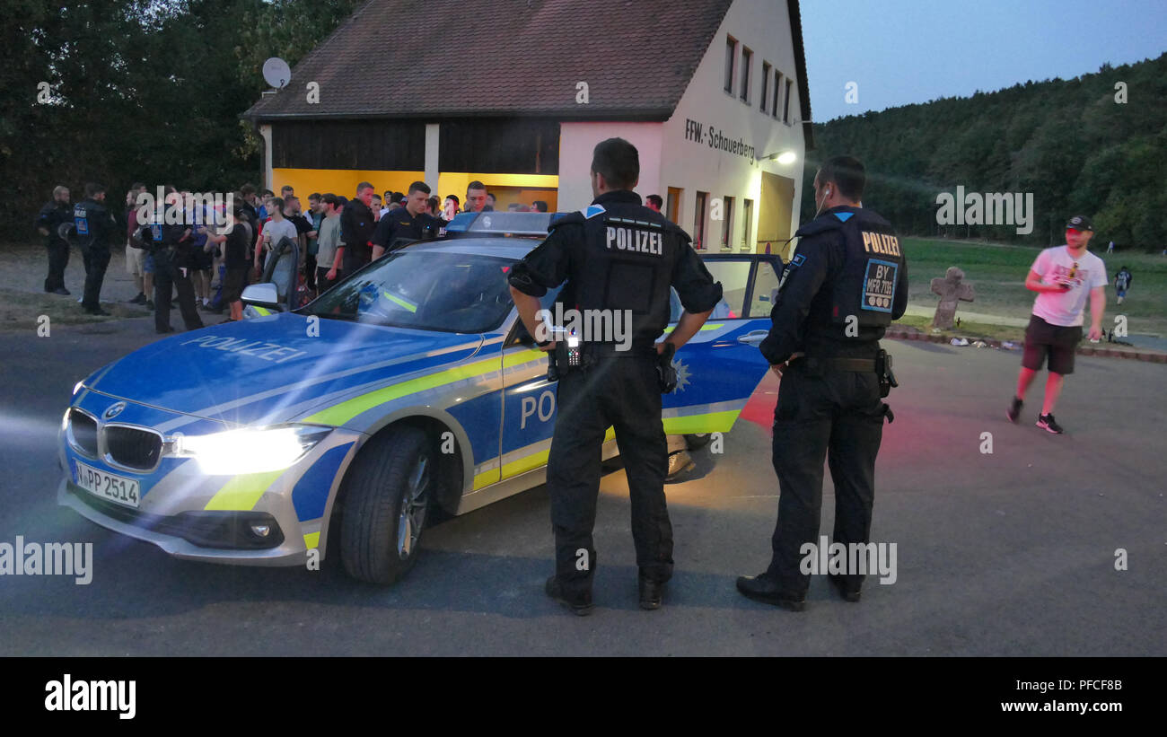 Emskirchen, Germany. 20th Aug, 2018. Police officers stand against the youtuber 'Dragonlord' in a hate demonstration. Despite a ban on meetings, several hundred people attended the demonstration. In the social media, mostly anonymous users had called for the event against the youtuber on Monday. Between the man who has been publishing videos about his life for several years and his opponents there is always a dispute. Credit: David Oßwald/NEWS5/dpa/Alamy Live News Stock Photo