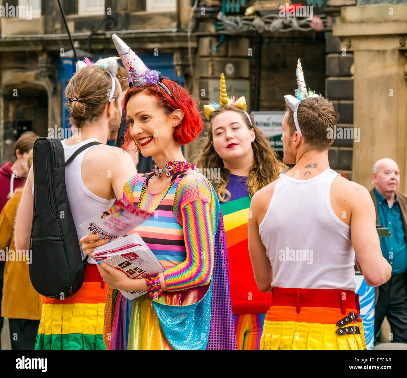 Edinburgh Fringe, Edinburgh, Scotland, UK. 21st August 2018. Fringe goers and festival performers throng the Virgin Money sponsored street venue on the Royal Mile in the last week of the fringe festival. Fringe performers in colourful costumes from a show called Broken Romantics had out flyers to people passing by Stock Photo