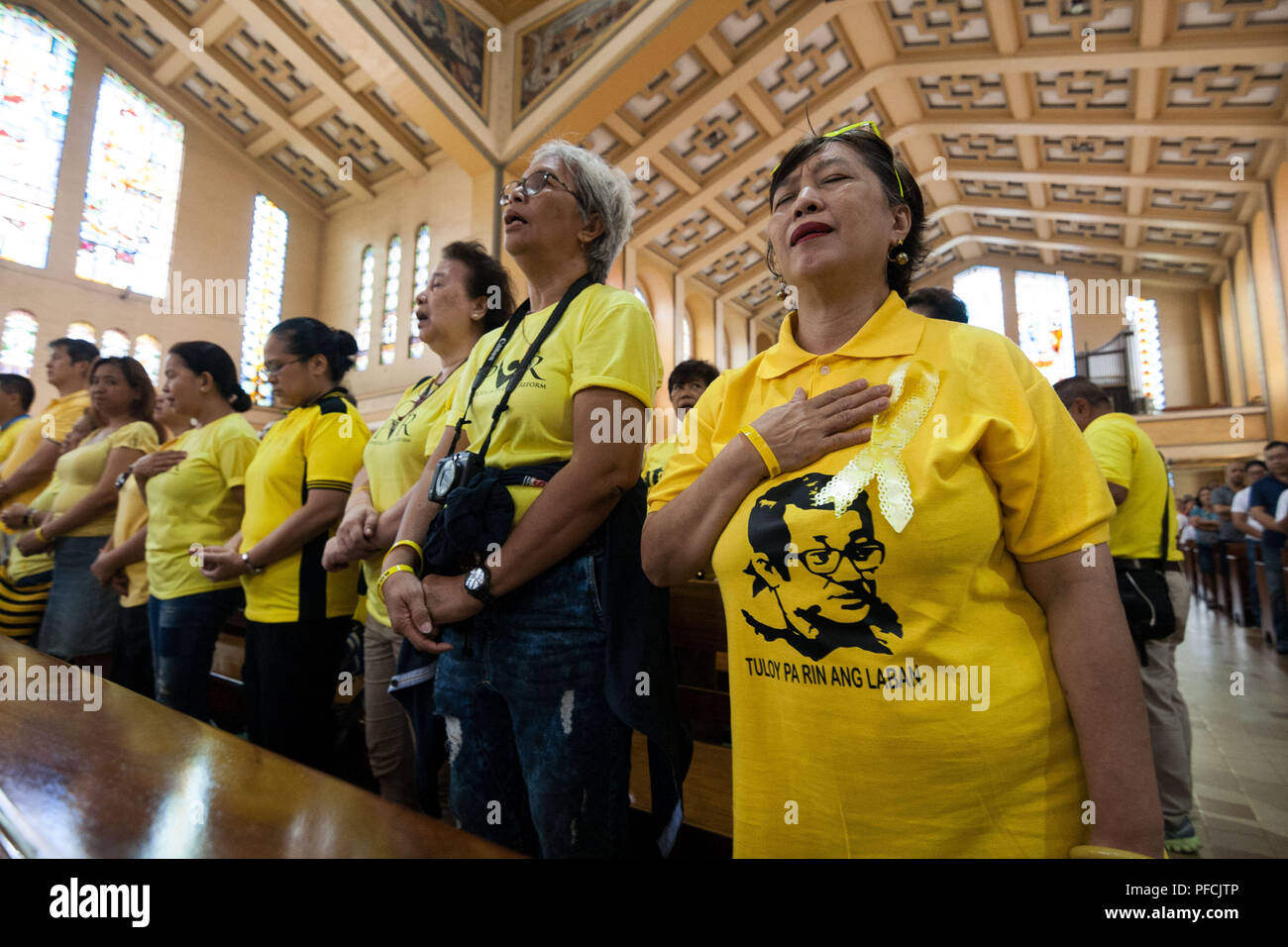 Philippines. 21st Aug, 2018. Supporters wear yellow with the face of Ninoy Aquino at the mass in Sto. Domingo Church. Former president Benigno Aquino III lead the mass commemorating the 35th year anniversary of his father's assassination. Benigno ''Ninoy'' Aquino Jr. was assassinated on August 21, 1983 while going down the staircase of a plane at the Manila International Airport. Credit: J Gerard Seguia/ZUMA Wire/Alamy Live News Stock Photo