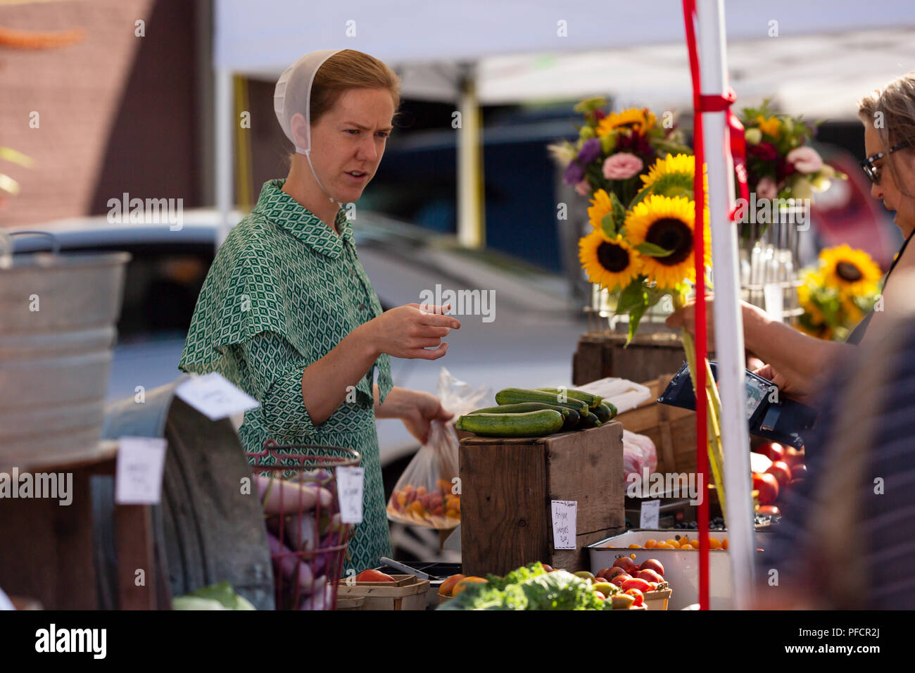 An Amish woman selling produce at the farmer's market in Zionsville, Indiana. Stock Photo