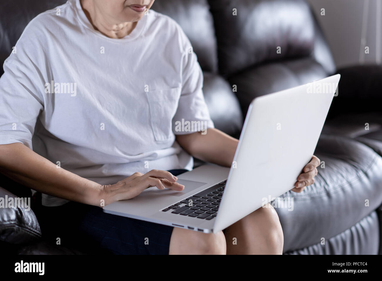 Elderly woman using her computer in home and using laptop Stock Photo