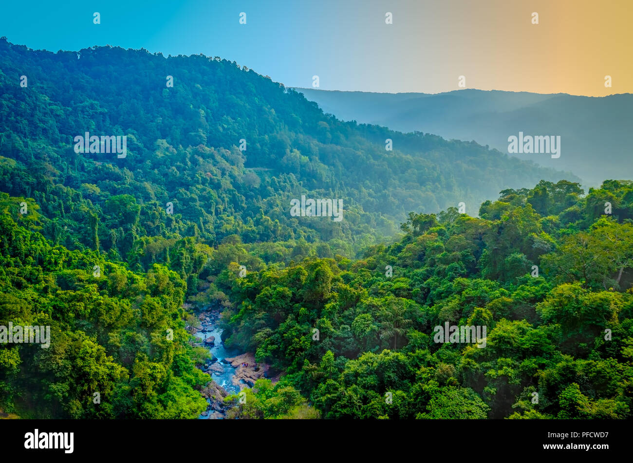 A stream flowing through green mountain range. Landscape from Maharashtra, India. Stock Photo