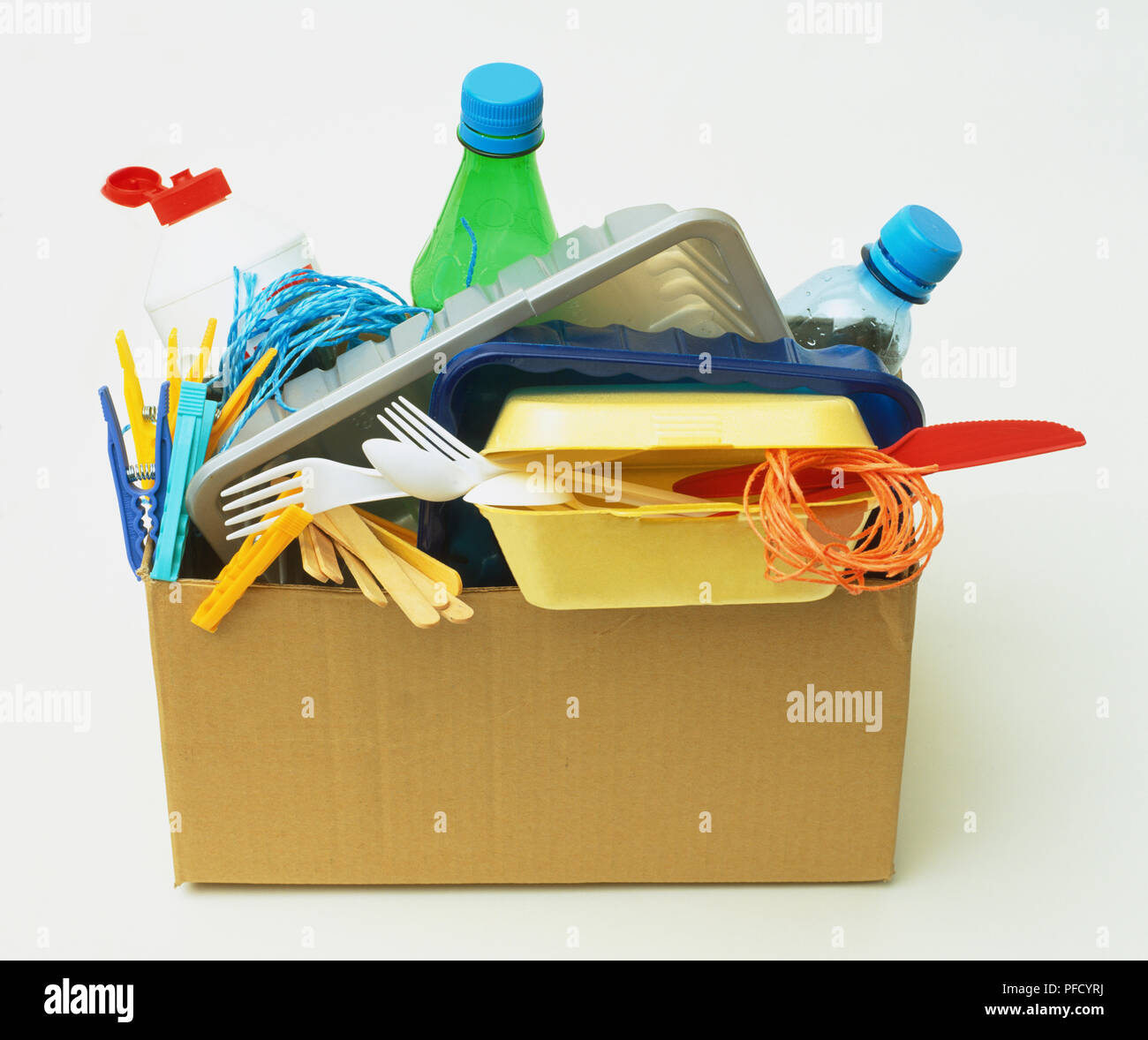Cardboard box overflowing with plastic utensils, containers and pegs