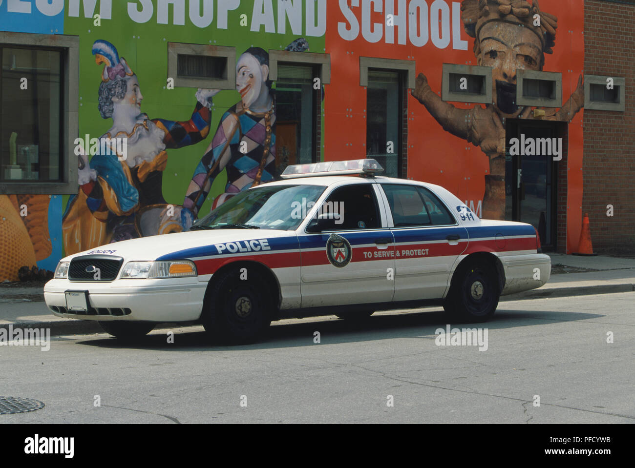 Canada, Toronto, police car parked by colourful wall mural, side view. Stock Photo