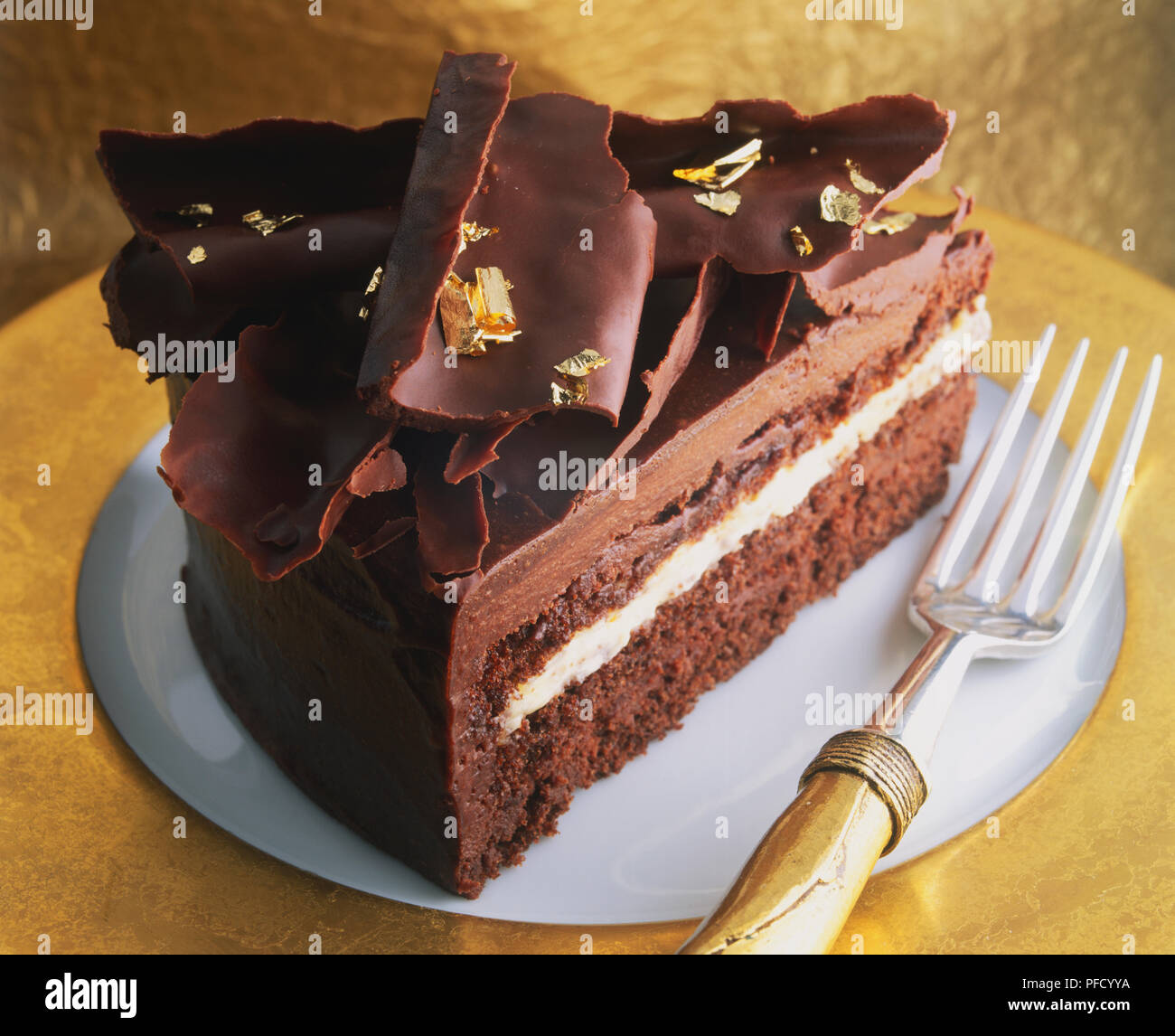 Slice of filled and iced chocolate cake decorated with chocolate ...