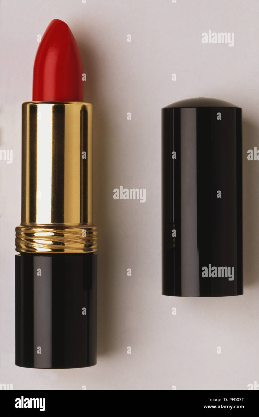 Red lipstick with lid removed on the side, close up. Stock Photo