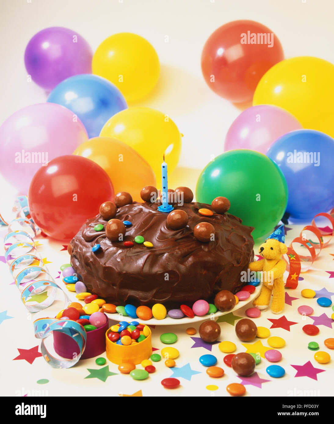 Small Chocolate Cake Decorated With Sweets And A Lit Candle