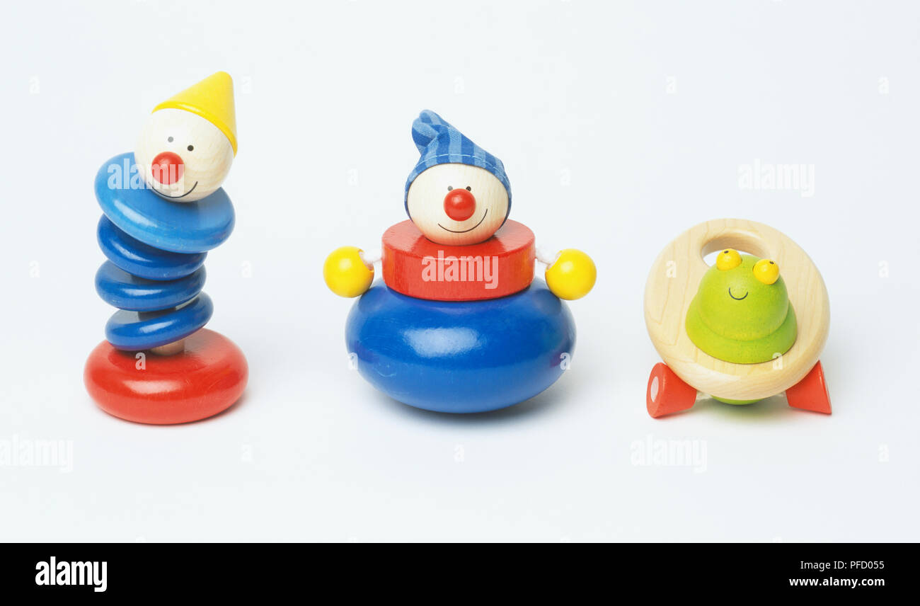 Colourfully painted wooden statuettes of two clowns and a frog, front view. Stock Photo