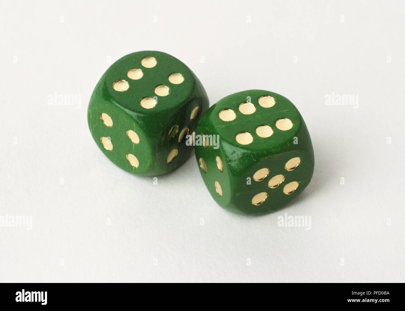 Two green dice with gold dots, close up. Stock Photo