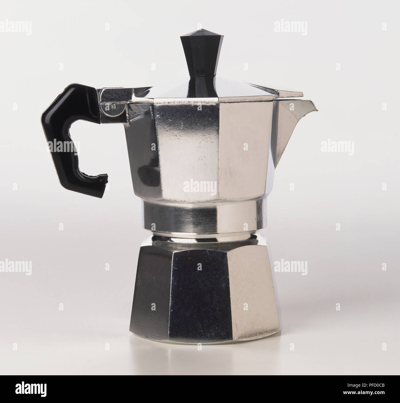 Angular metal coffee maker with a black handle, side view. Stock Photo