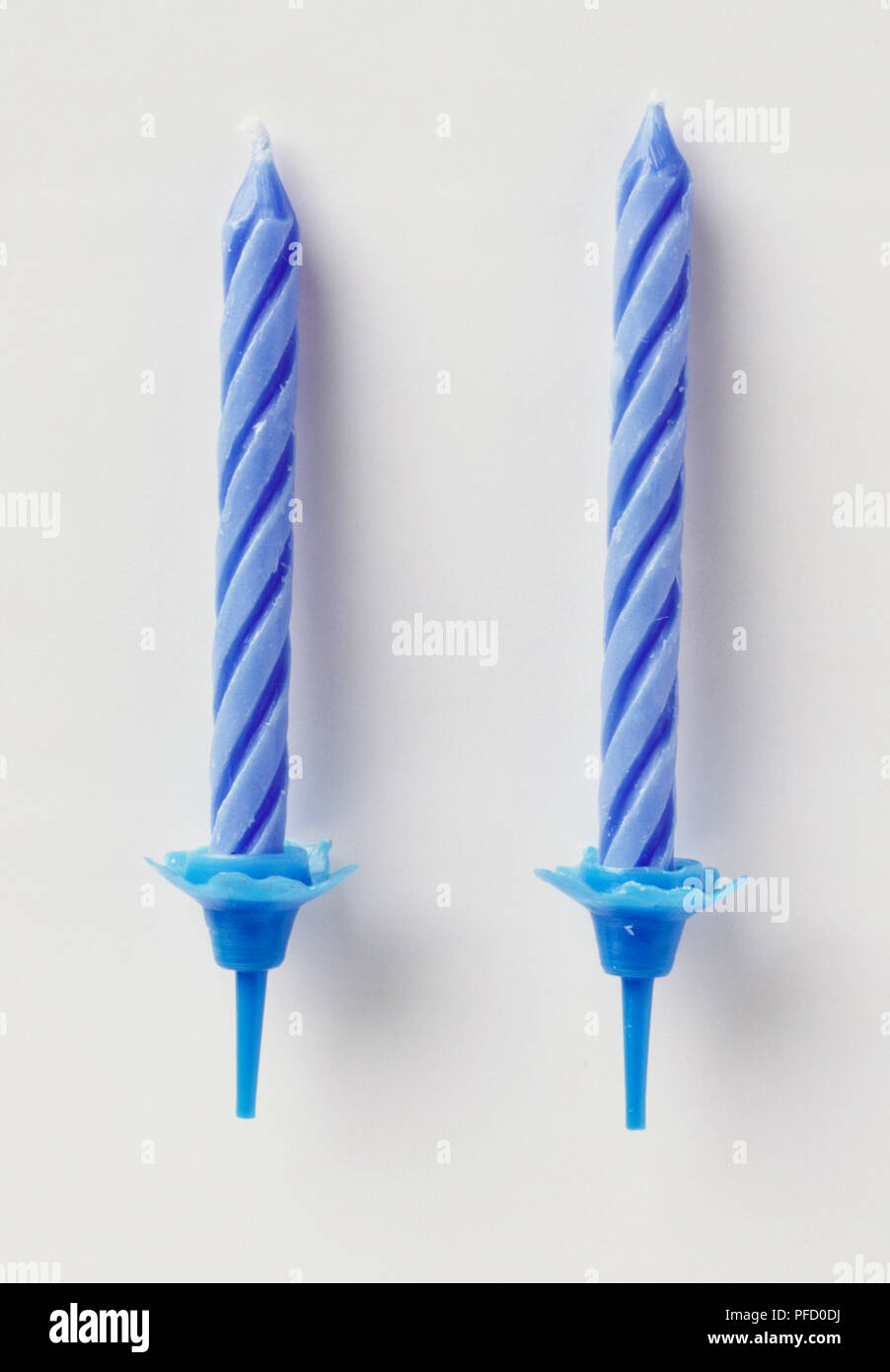 Two blue birthday candles in cake holders, close up. Stock Photo