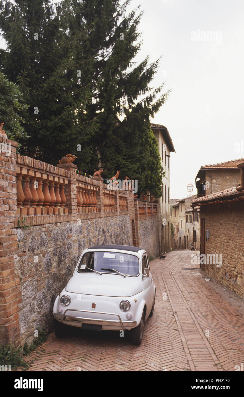 Italy, Central Tuscany, San Gimignano, old Fiat 500 parked by wall in back street Stock Photo