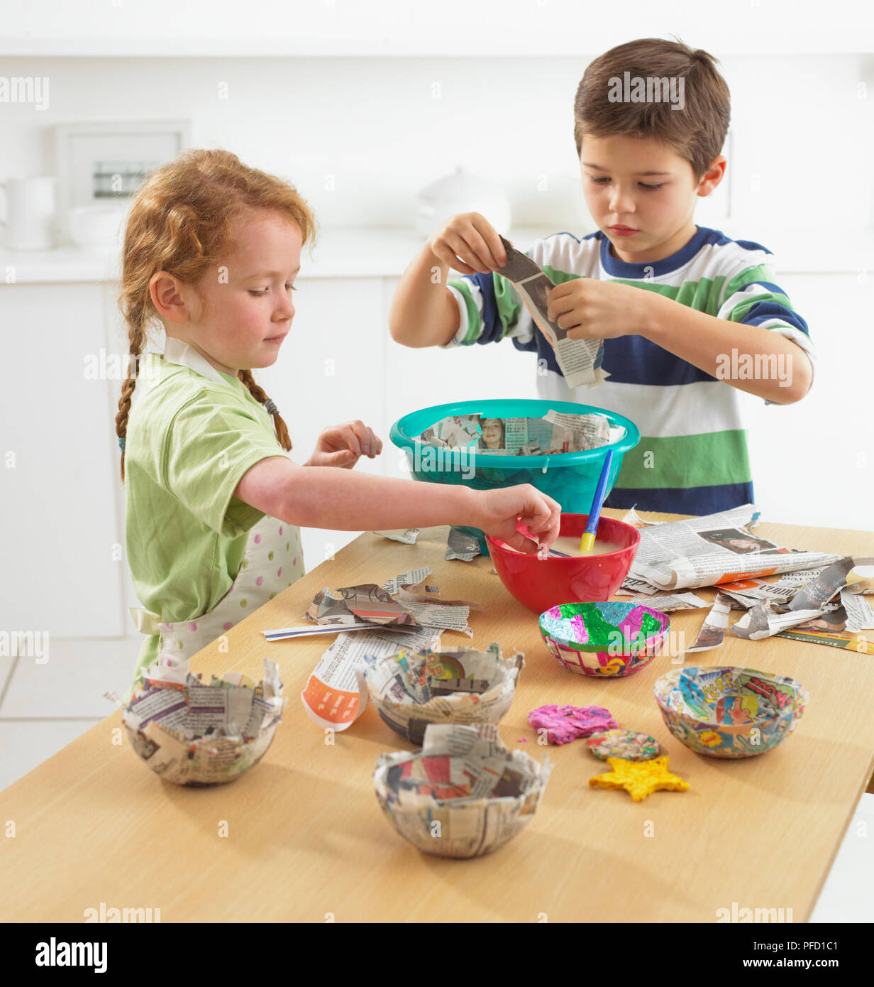Children making papiermache bowls on kitchen table Stock Photo Alamy